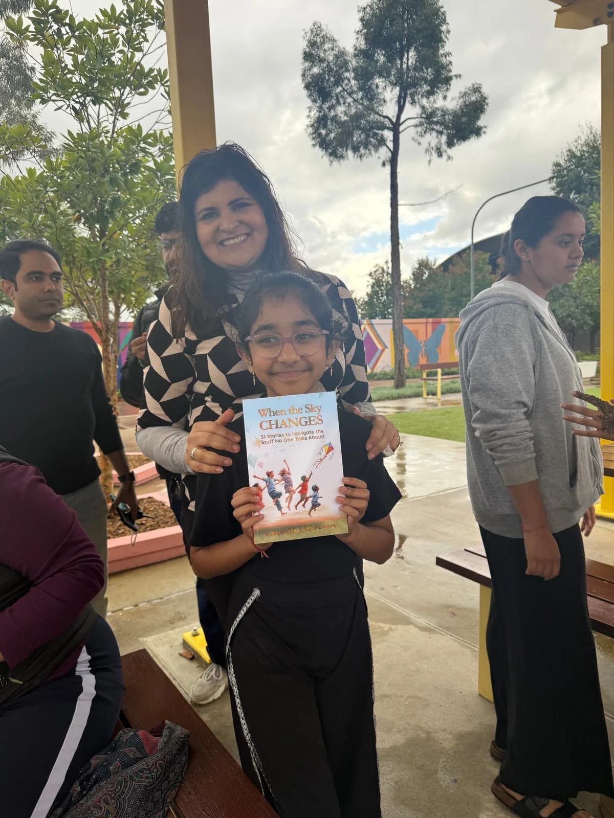A young community reader holding When the Sky Changes